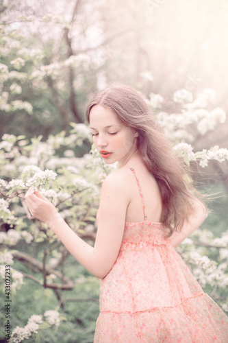 Portrait of a beautiful girl near a blossoming tree