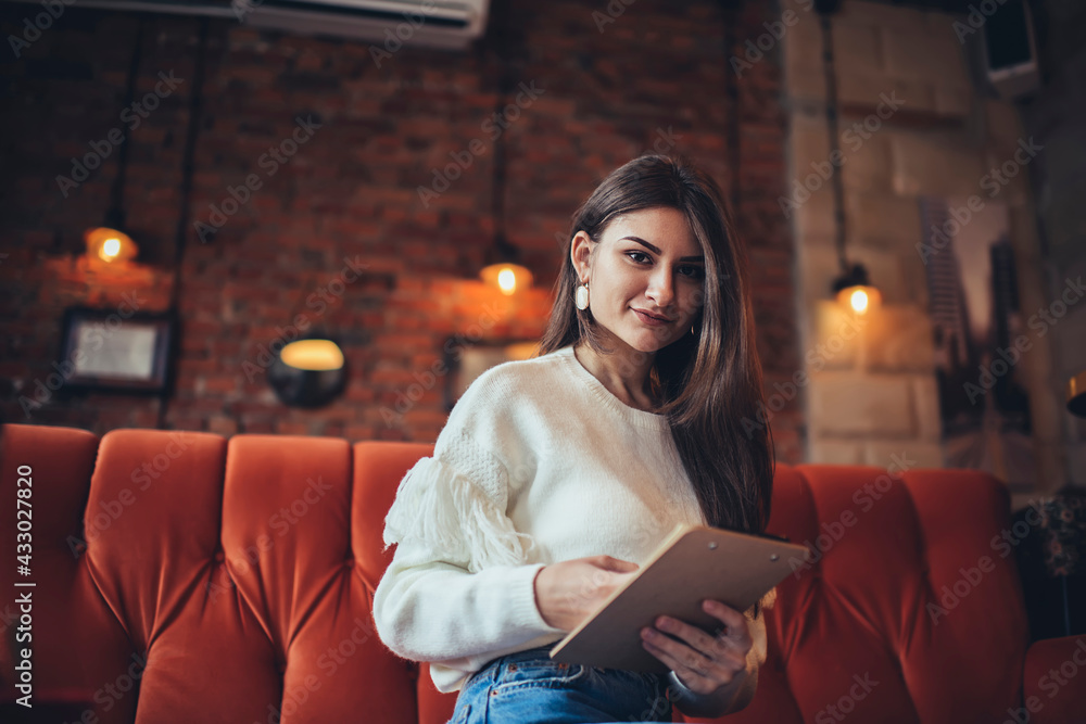 Obraz premium Calm woman with clipboard in cafe