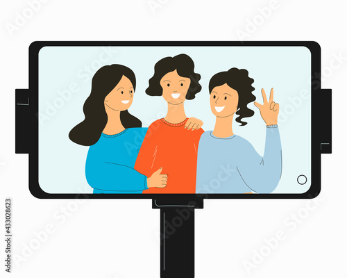 Photo on the phone with the help of a selfie stick of three women