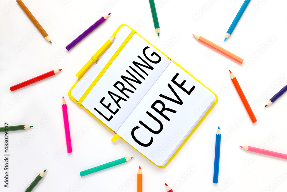 learning curve. bright open notebook on a white background and bright pencils learning curve. bright open notebook on a white background and bright pencils