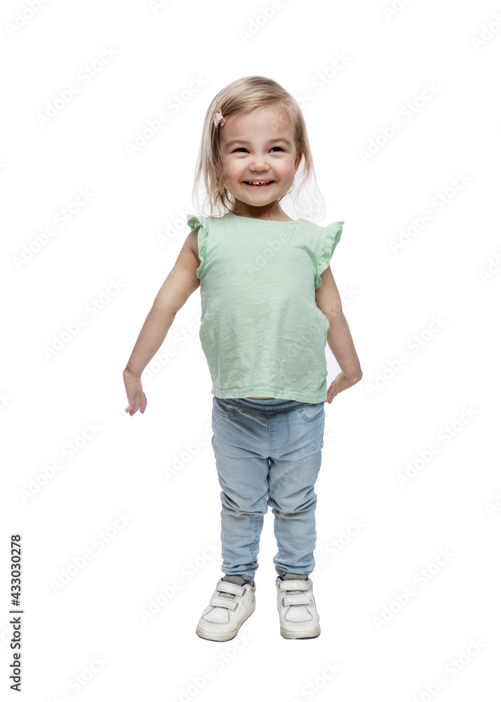 Smiling little girl 2 years old in jeans stands. Happiness and love. Full height. Isolated on white background. Vertical. Smiling little girl 2 years old in jeans stands. Happiness and love. Full height. Isolated on white background. Vertical.