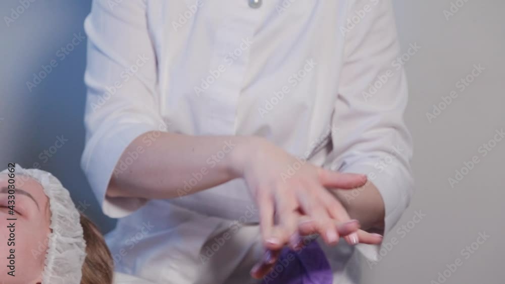 Woman beautician treats her hands with an antiseptic. Woman beautician treats her hands with an antiseptic.