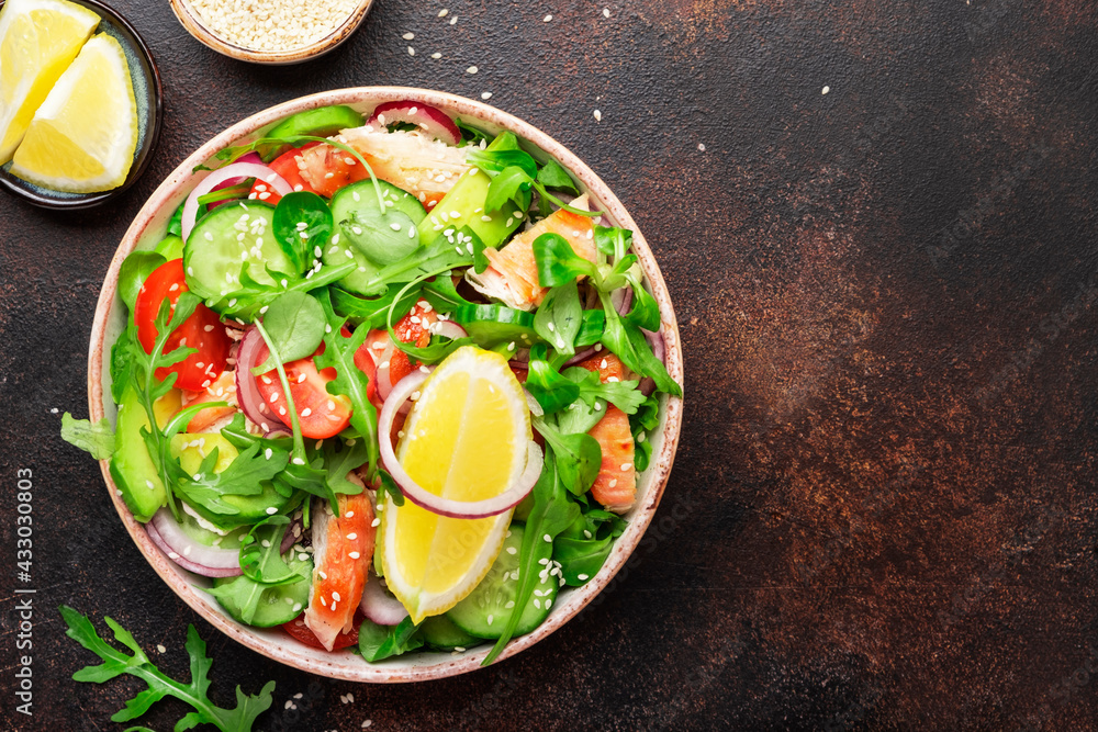 Salad with grilled chicken, tomatoes, arugula, red onion, avocado, sesame seeds and lemon oil dressing. Healthy food. Top view Salad with grilled chicken, tomatoes, arugula, red onion, avocado, sesame seeds and lemon oil dressing. Healthy food. Top view