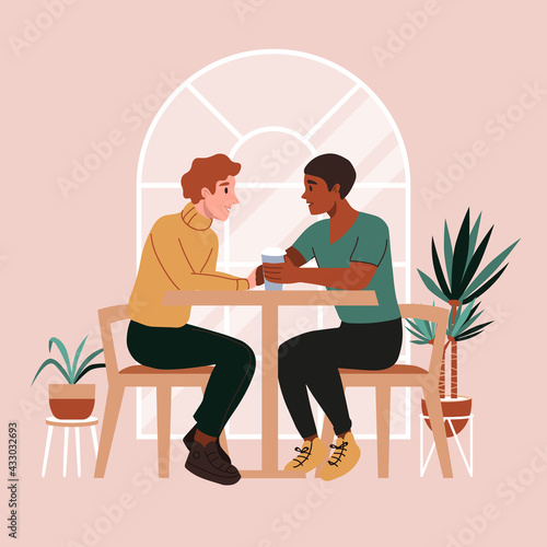 Gay couple on a date at cafe. First date or valentines day. Romantic scene with lgbt family, marriage. Two men drinking coffee, talking and smiling, holding hands.