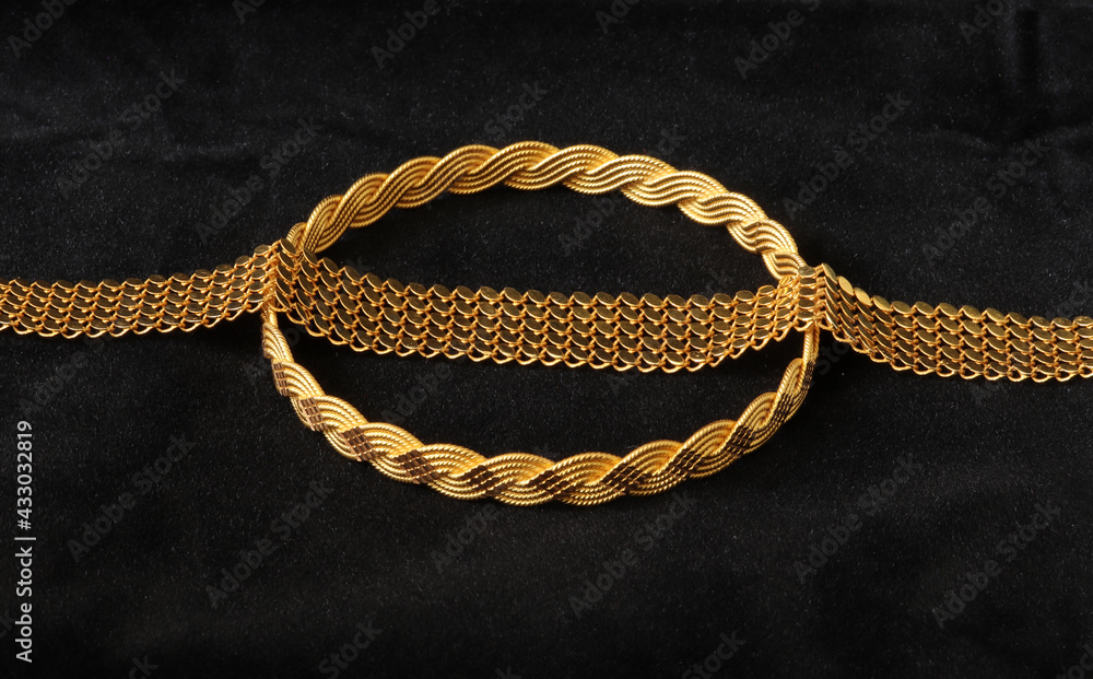 gold bracelets on a black background