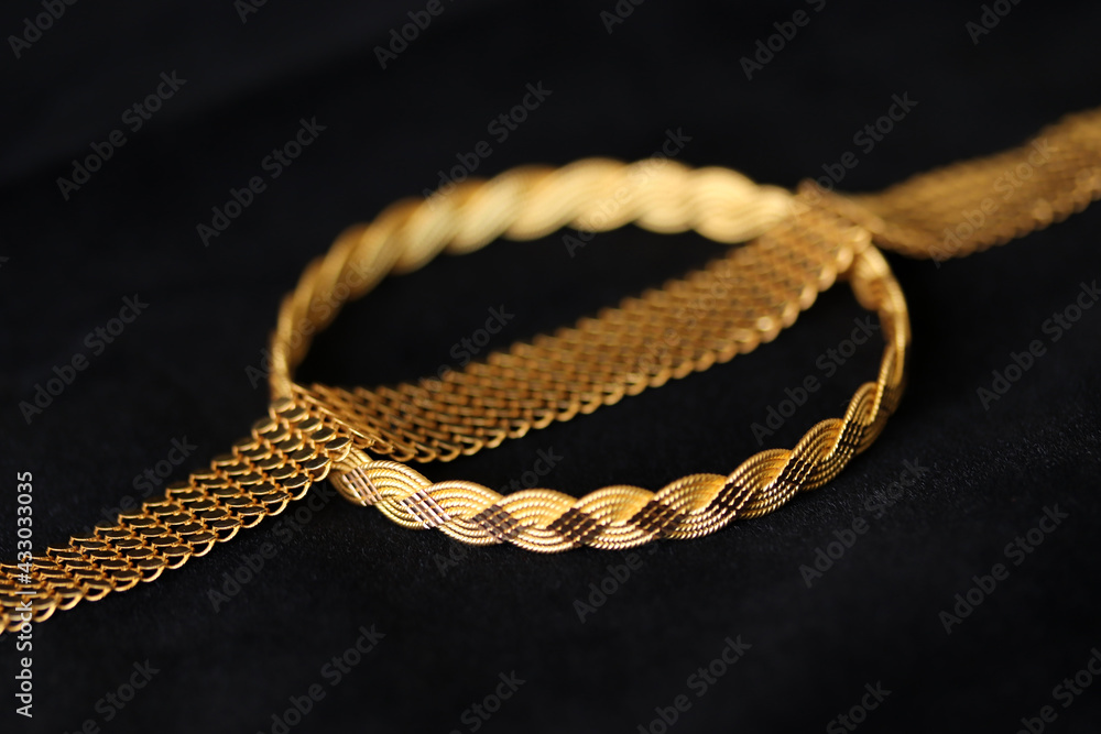 gold bracelets on a black background gold bracelets on a black background