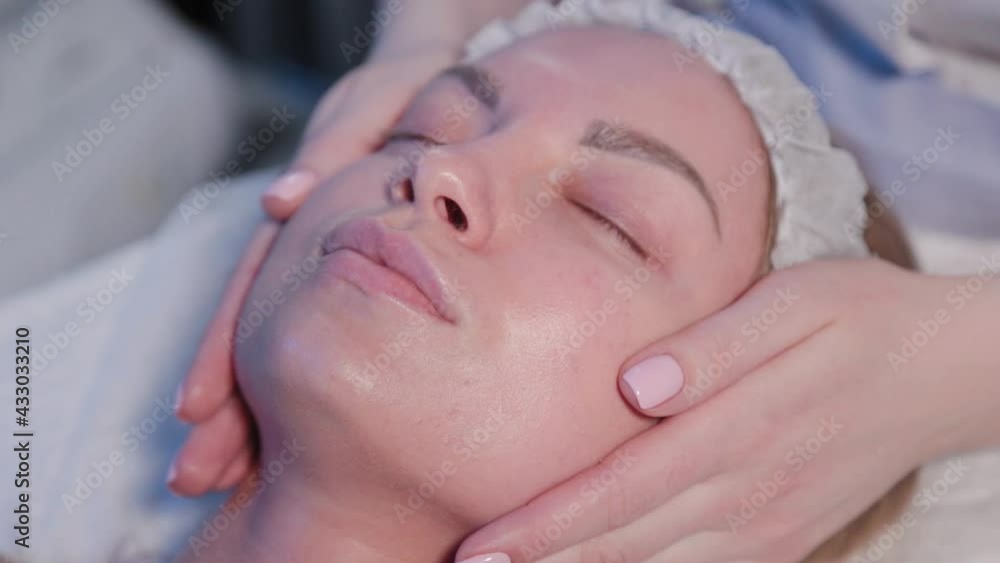 Woman cosmetologist applies cosmetic cream on woman face. Woman cosmetologist applies cosmetic cream on woman face.