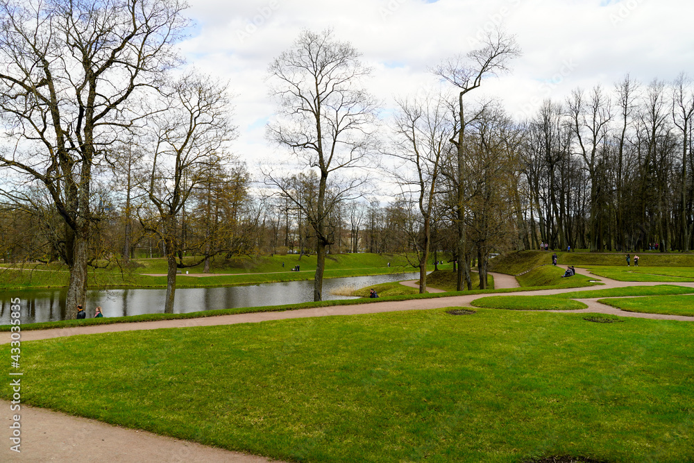Landscape of the park with a river and strolling people