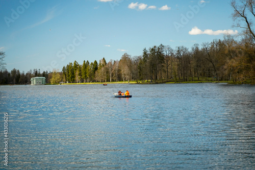 A boat with passengers in life jackets floating on the river