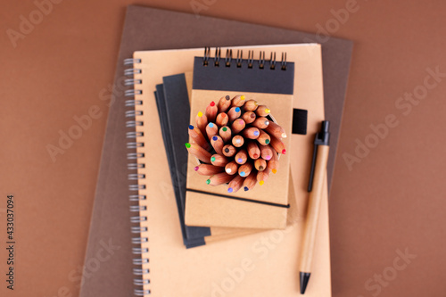 branding mockup with many craft paper and different subjects. Office desk with a paper notepad and a box of pencils. Contemporary workspace for men, minimalist style. Mockup. Copy space. Above photo