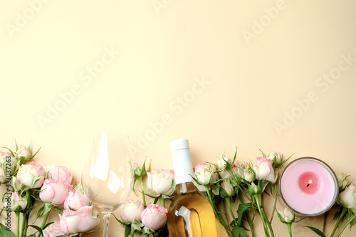 Romantic concept with roses, wine and candles on beige background