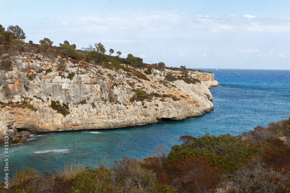 Rocky seashore. Steep coast. A steep cliff near the sea. Porto Cristo, Mallorca. Travel Concept. High quality photo