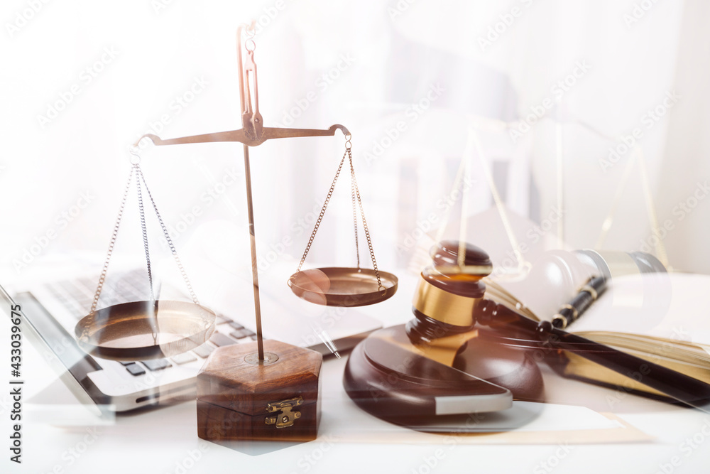 Business and lawyers discussing contract papers with brass scale on desk in office. Law, legal services, advice, justice and law concept picture with film grain effect Business and lawyers discussing contract papers with brass scale on desk in office. Law, legal services, advice, justice and law concept picture with film grain effect