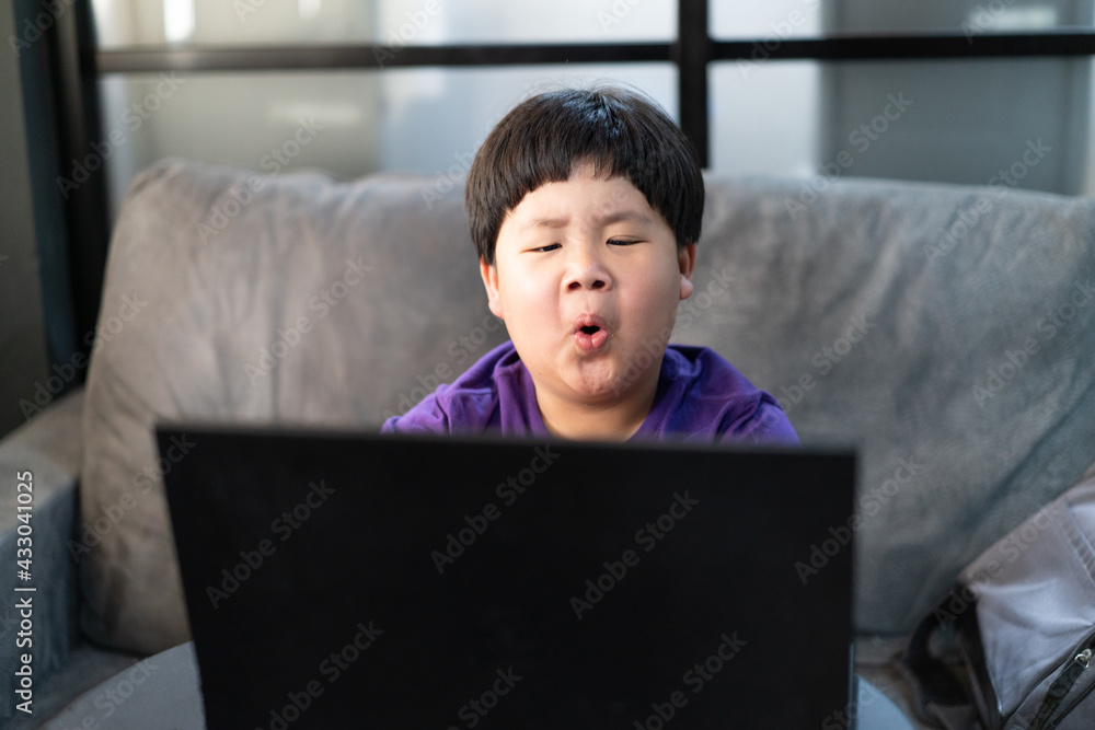 A boy stays home and studying online. A boy stays home and studying online.