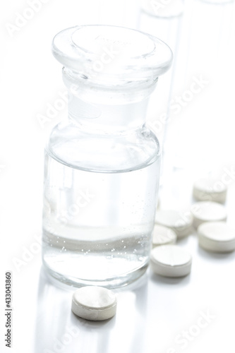 doctor's office table with pills and vials white background