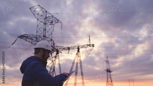 Worker energy worker conducts repairs of power engineering with a tablet, preventive work of an engineer, electricity under voltage network, planet business technologies concept