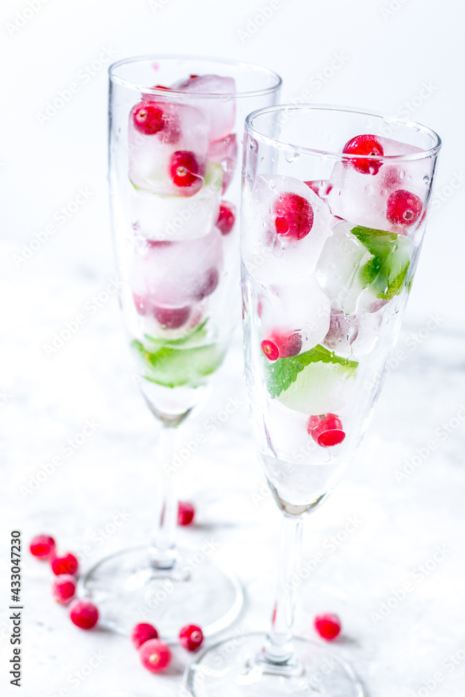 Ice cubes with berries and mint in glasses for summer drink white background Ice cubes with berries and mint in glasses for summer drink white background