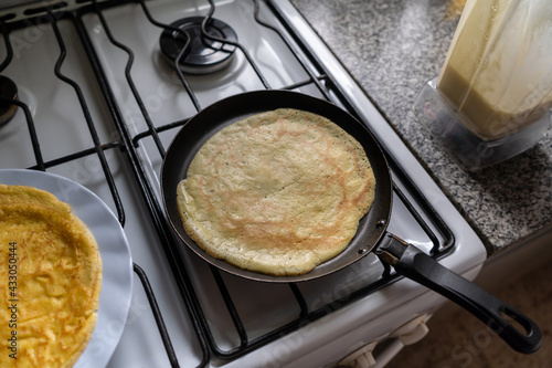 Pancakes cooking in a pan on the stove.