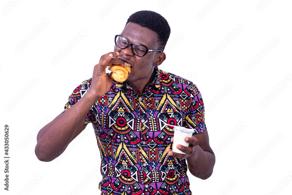 portrait of a handsome young man eating croissant portrait of a handsome young man eating croissant