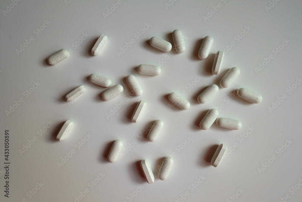 Multiple white caplets of kelp dietary supplement from above Multiple white caplets of kelp dietary supplement from above
