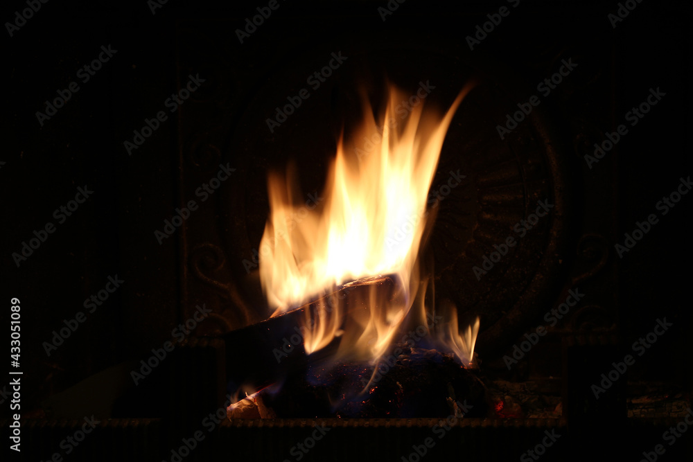 Firewood burns in the fireplace. Shooting at night. Closeup