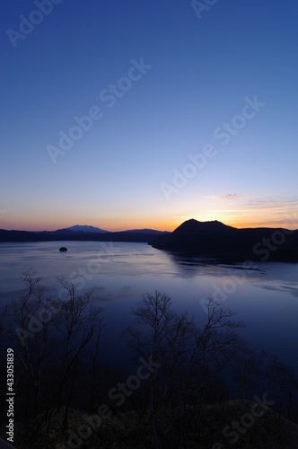 美しいグラデーションの夜明けの空と湖。日本の北海道の摩周湖。