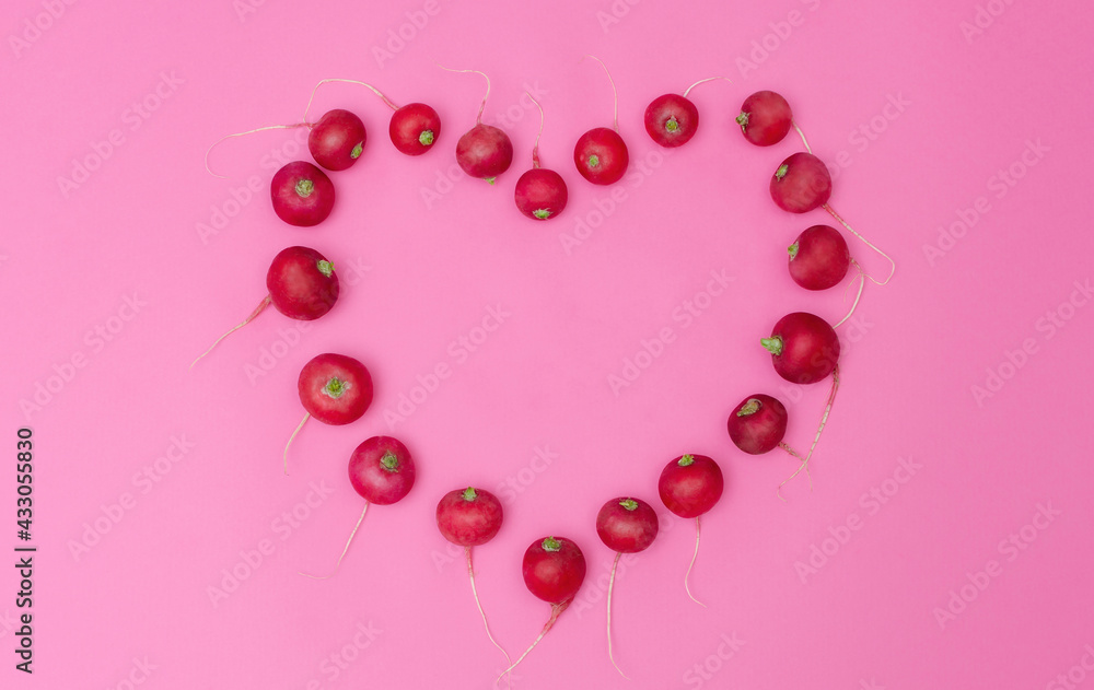 Radish shaped like a heart on a pink background. Valentine day/