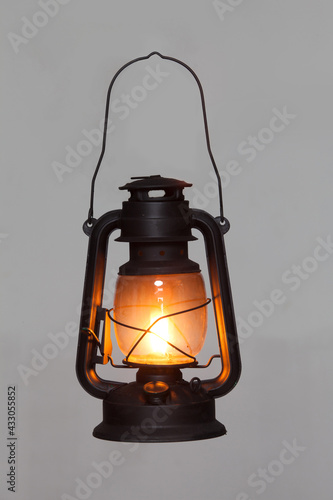 old vintage rusty kerosene black lamp isoleted on gray background. Glass oil lamp. Storm lantern. object vintage concept photo