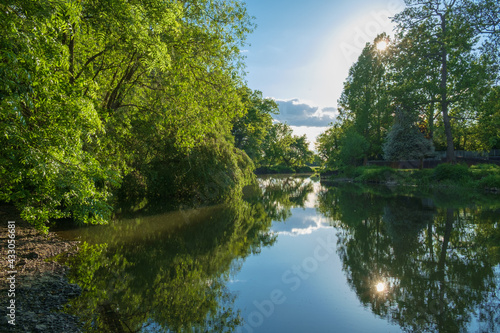 The River Mole, Near Esher, Surrey, England, UK. The tree-lined river and still water creates a tranquil scene.