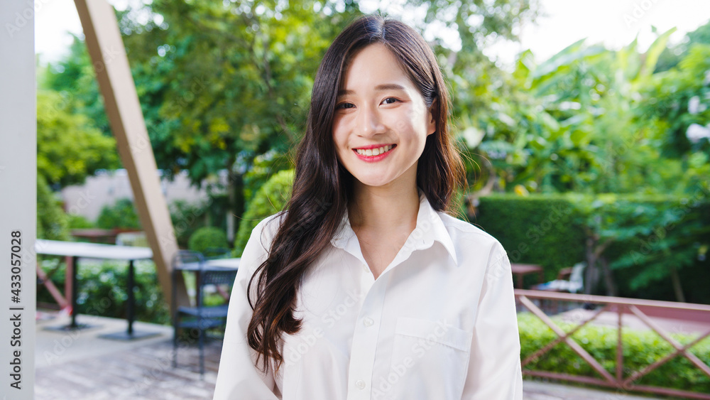 Happy young Asian female feeling happy smiling and looking to camera while relax on street in modern city. Lifestyle woman at outside house concept. Happy young Asian female feeling happy smiling and looking to camera while relax on street in modern city. Lifestyle woman at outside house concept.