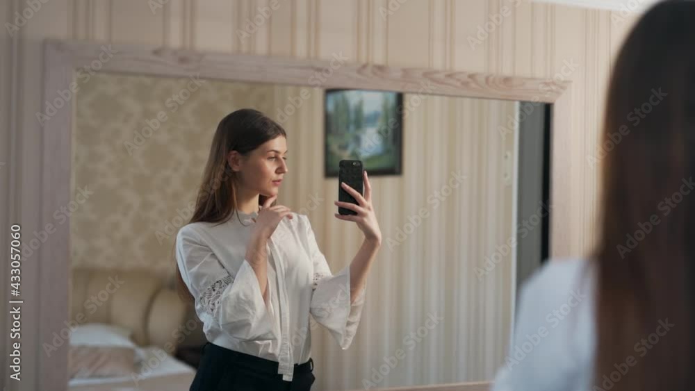 Portrait of a beautiful woman in the mirror taking pictures on a smartphone Portrait of a beautiful woman in the mirror taking pictures on a smartphone