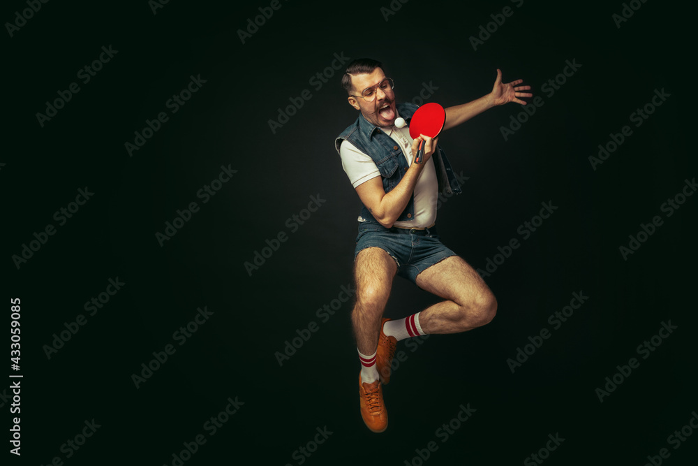 Young caucasian man playing tennis isolated on black studio background in retro style, action and motion concept Young caucasian man playing tennis isolated on black studio background in retro style, action and motion concept