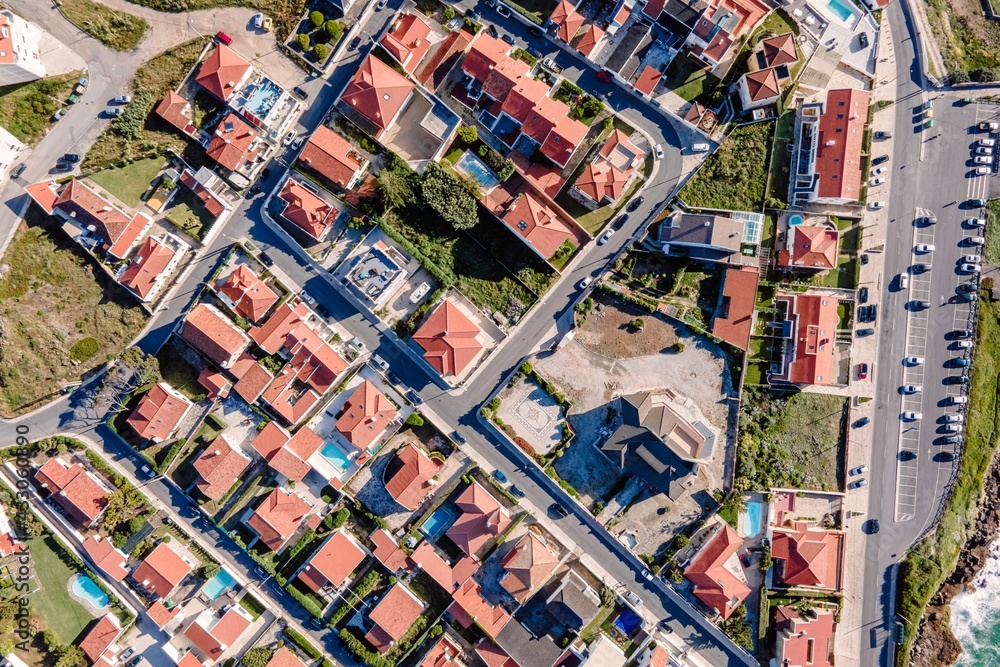 Aerial view of Praia das Macas little township from top, view of the red rooftop of a small town along Portuguese shoreline, Colares, Portugal. Aerial view of Praia das Macas little township from top, view of the red rooftop of a small town along Portuguese shoreline, Colares, Portugal.