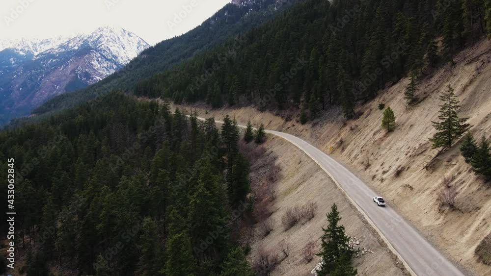White truck drives along road through forest landscape in British Columbia, Canada. White truck drives along road through forest landscape in British Columbia, Canada.