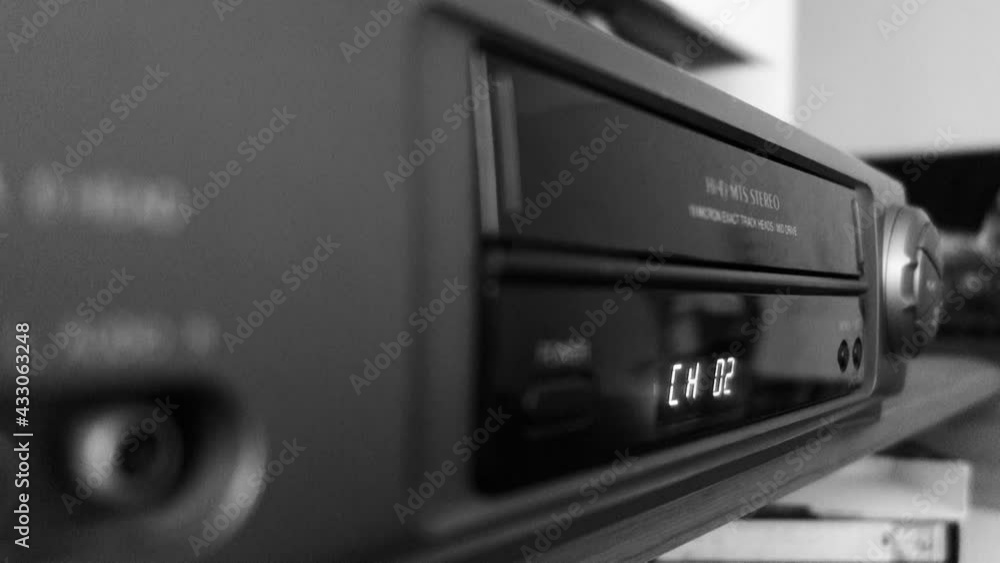 inserting VHS tape on Video cassette recorder. VCR timer display, black and white inserting VHS tape on Video cassette recorder. VCR timer display, black and white
