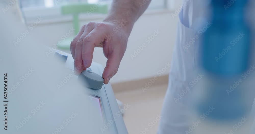 Close-up a male medical hand is pressing a button on the multichannel syringe pump. Close-up a male medical hand is pressing a button on the multichannel syringe pump.
