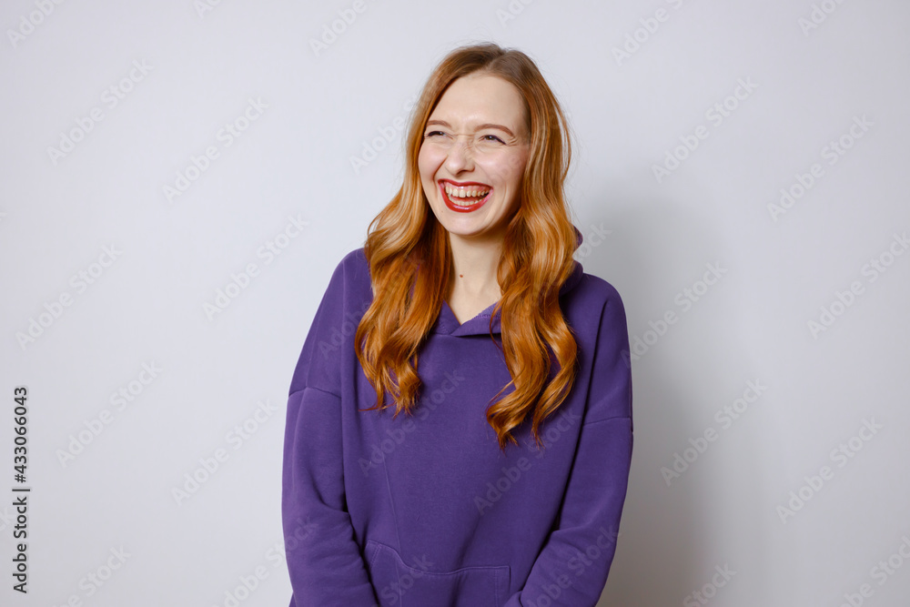 Funny redhead girl in purple hoodie. White background Funny redhead girl in purple hoodie. White background