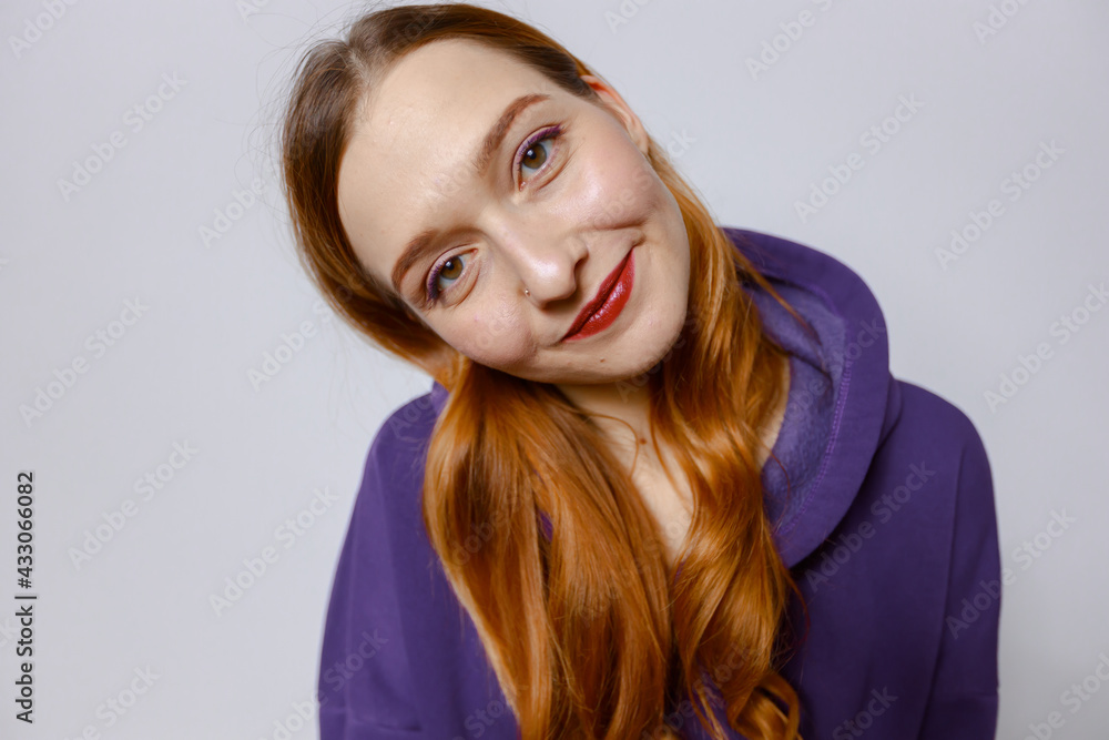 Funny redhead girl in purple hoodie. White background Funny redhead girl in purple hoodie. White background