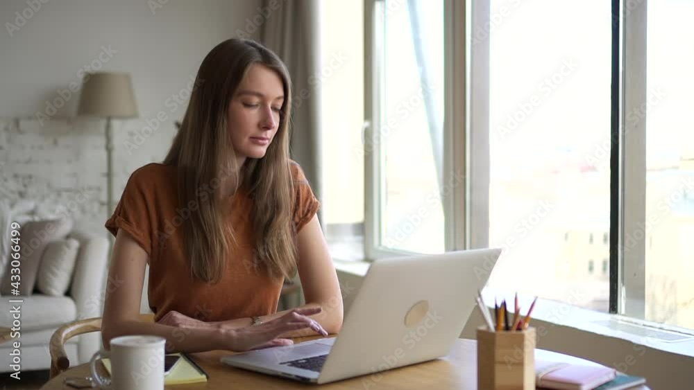 Woman sit at home and think of idea while working at laptop. Young millennial female look aside Woman sit at home and think of idea while working at laptop. Young millennial female look aside
