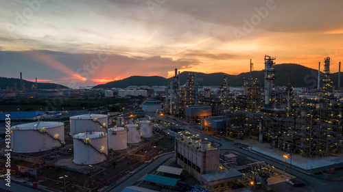 Chemical oil refinery plant, power plant and metal pipe on sunset sky background.