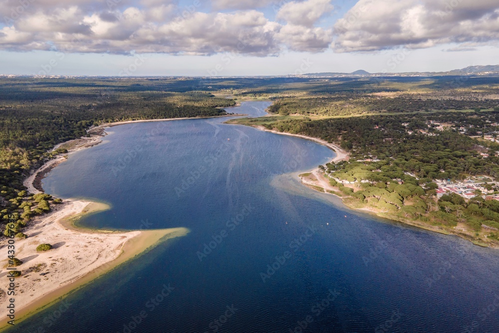 Aerial view of Lagoa de Albufeira, a natural lake meeting the Atlantic Ocean in south Portuguese coastline, Sesimbra Municipality, Setubal, Portugal. Aerial view of Lagoa de Albufeira, a natural lake meeting the Atlantic Ocean in south Portuguese coastline, Sesimbra Municipality, Setubal, Portugal.