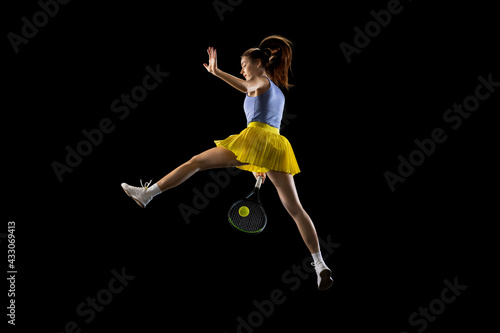 Young caucasian woman playing tennis isolated on black studio background in action and motion, sport concept © master1305