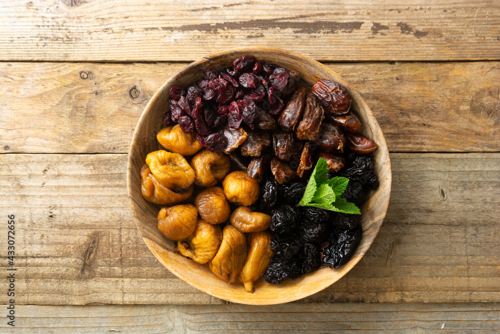 Dried fruits on wooden plate, healthy snack, sweet fruits, rustic style Dried fruits on wooden plate, healthy snack, sweet fruits, rustic style