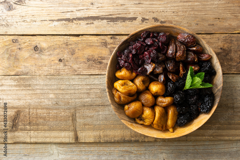 Dried fruits on wooden plate, healthy snack, sweet fruits, rustic style Dried fruits on wooden plate, healthy snack, sweet fruits, rustic style