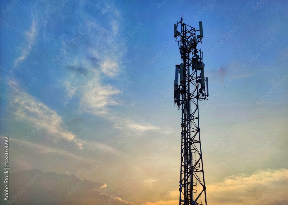 Telecommunications tower during sunset with blue and orang sky