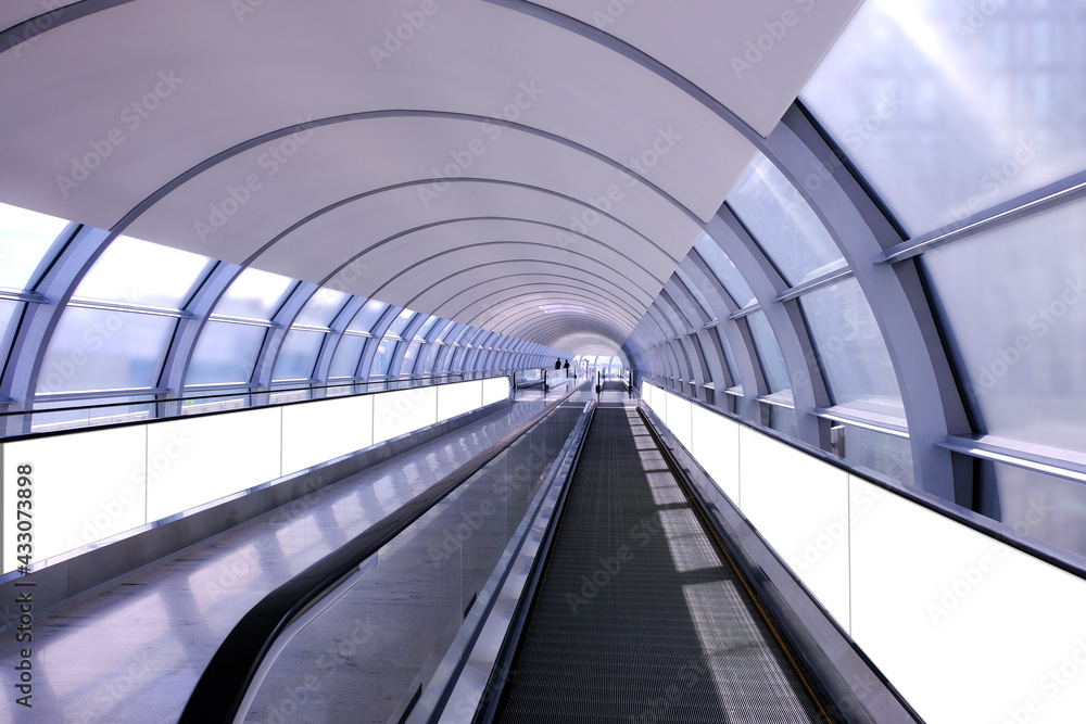 Visual mockup for advertising banner display on moving walkway travelator in long pedestrain tunnel. Blank billboard advertising space for mock up purpose; OOH in situ ad placement. Visual mockup for advertising banner display on moving walkway travelator in long pedestrain tunnel. Blank billboard advertising space for mock up purpose; OOH in situ ad placement.