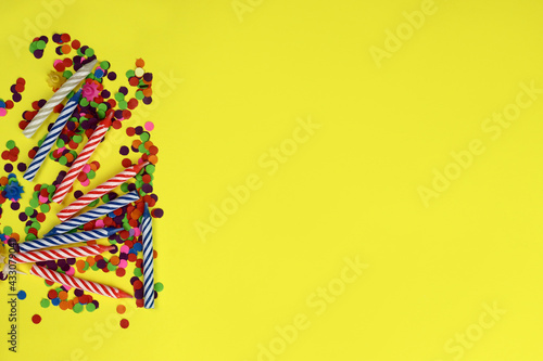 Colorful birthday candles on a yellow background