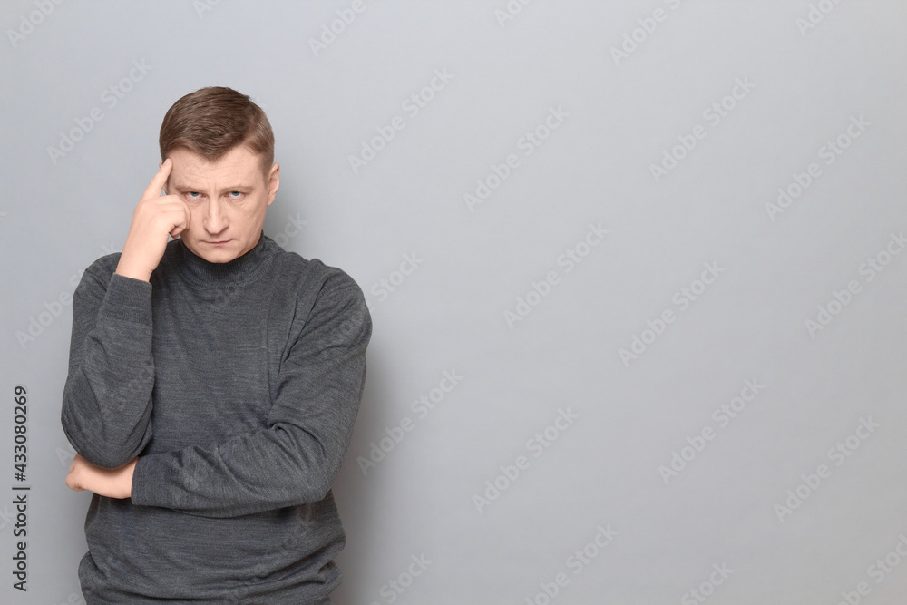 Portrait of thoughtful serious mature man touching temple with hand Portrait of thoughtful serious mature man touching temple with hand