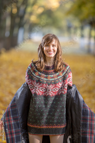 ortrait of beautiful woman wearing sweater in autumn yellow park	