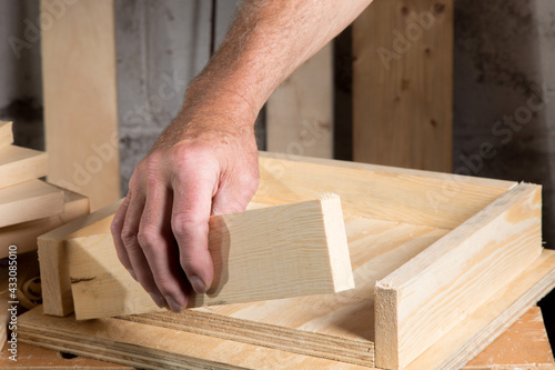 a male carpenter's hand assembling a woodworking project